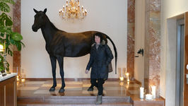 Foto zeigt eine Slanina-Mitarbeiterin vor einer großen Pferd-Statue.